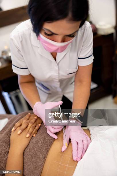 woman at the spa getting fat burning injections in her abdomen - fat burning stock pictures, royalty-free photos & images