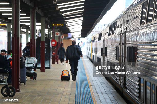 Commuter rushes along a platform to catch a train at Central Station on June 30, 2022 in Sydney, Australia. Sydney commuters face ongoing train...