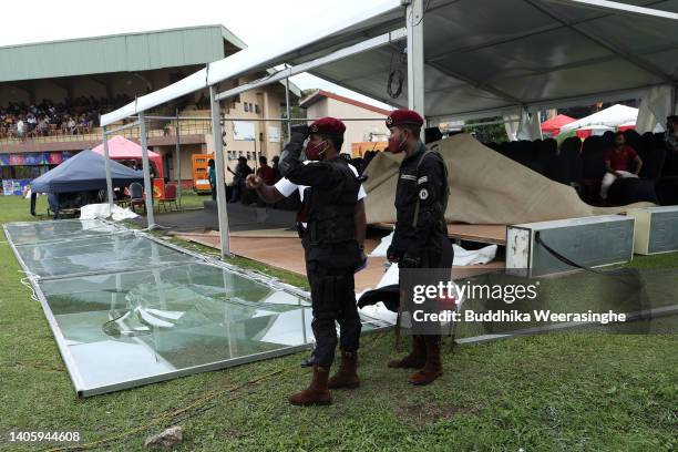 Army officers stand next to a partially collapsed tent caused by bad weather during day two of the First Test in the series between Sri Lanka and...