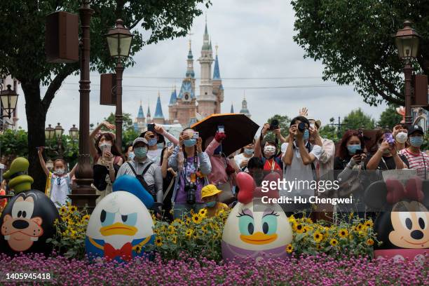 People take photos in front of the Enchanted Storybook Castle at Shanghai Disneyland on June 30, 2022 in Shanghai, China. Shanghai's Disneyland theme...