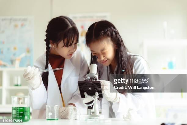 studenti di scienze con microscopio in classe bangkok, thailandia - girl liquid foto e immagini stock