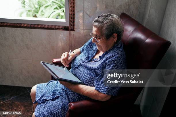 old woman using an tablet - bolígrafo digitalizado fotografías e imágenes de stock