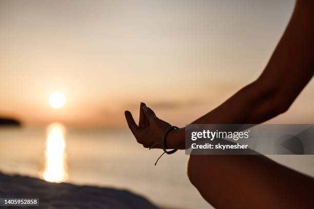 meditieren am strand bei sonnenaufgang! - schneidersitz stock-fotos und bilder