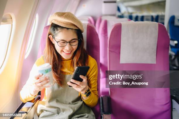 happiness asian passenger sitting on a seat on plane. ready for traveling by plane. - aircraft wifi stock pictures, royalty-free photos & images