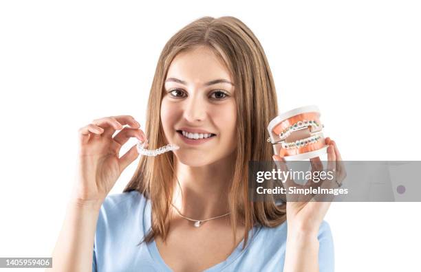 dental braces or invisible silicone trainer in the hands of a young teenage girl. orthodontic concept - invisalign. - invisalign stockfoto's en -beelden