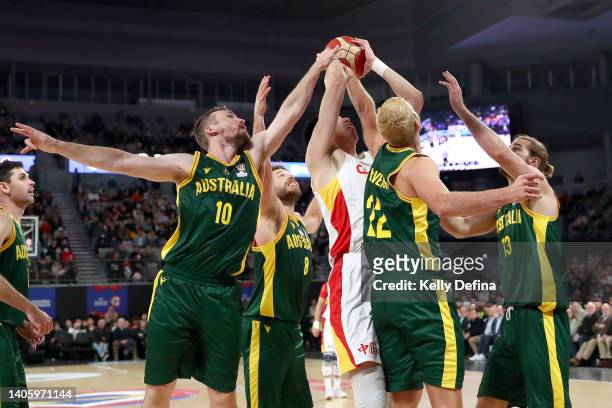 Qi Zhou of China shoots against Mitch McCarron of Australia and Jack McVeigh of Australia during the FIBA World Cup Asian Qualifier match between the...