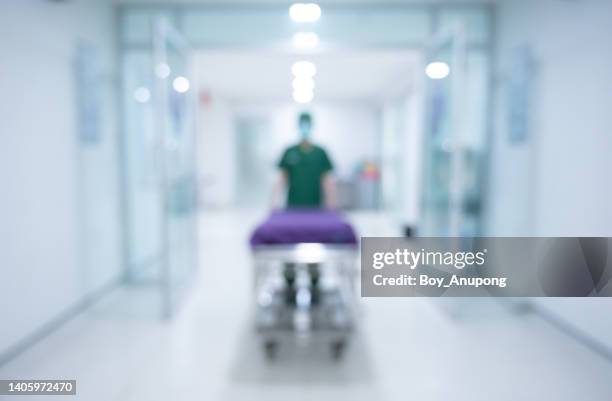 blurred image of an unidentified healthcare worker while pulling an emergency stretcher without patient at hospital corridor. - carrying sign imagens e fotografias de stock
