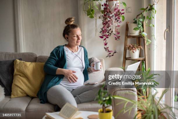 pregnant woman making video call with doctor - pregnant home stock pictures, royalty-free photos & images