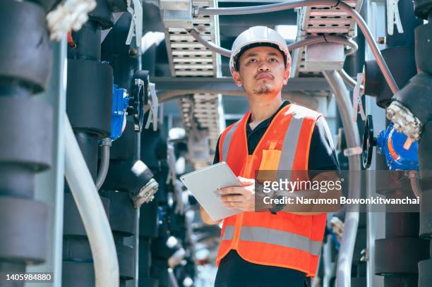the engineer inspecting the pipeline in the factory - platform shoe - fotografias e filmes do acervo