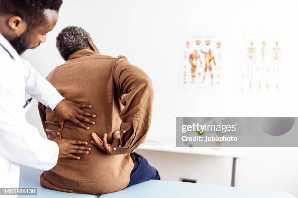 männliche arzthände bei der physiotherapie durch ausstrecken des rückens eines männlichen patienten - chiropractic stock-fotos und bilder