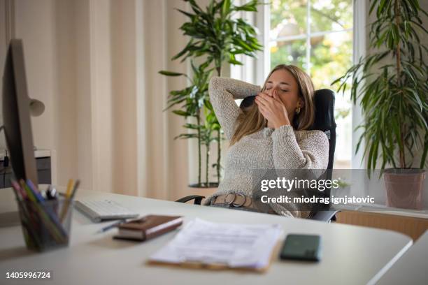 オフィスで疲れた若い白人女性 - あくび ストックフォトと画像