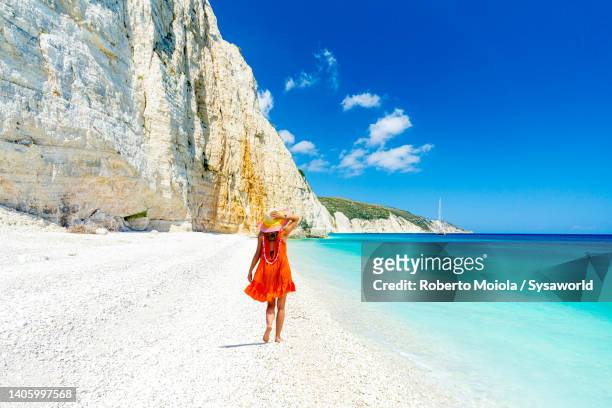 beautiful woman with dress walking on empty beach - greece holiday foto e immagini stock