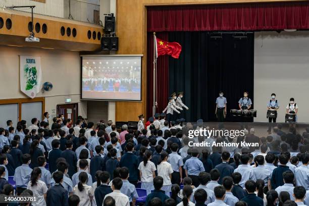 Students raise a Chinese national flag during a flag-raising ceremony to commemorate the 25th anniversary of Hong Kong handover at Scientia Secondary...