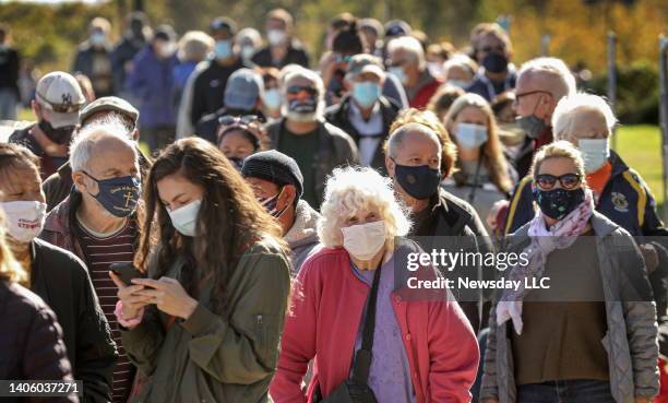 Hundreds of voters wearing masks, wait in line to vote at the early voting site at Brookhaven Town Hall in Farmingville, New York, on October 27,...