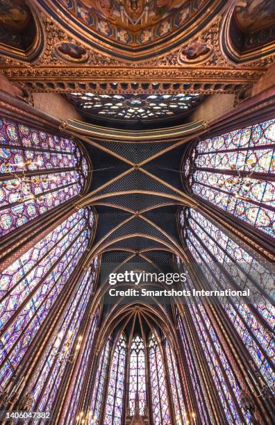 majestic gothic architecture with colorful light coming through the walls of sainte chapelle in paris, france - church color light paris stockfoto's en -beelden