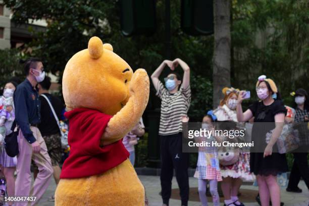 Cast member of Winnie the Pooh greets people at Shanhai Disneyland on June 30, 2022 in Shanghai, China.