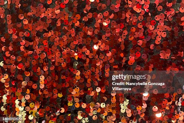 multi shades of  red and orange sequins on a fabric - glitter dress stock pictures, royalty-free photos & images