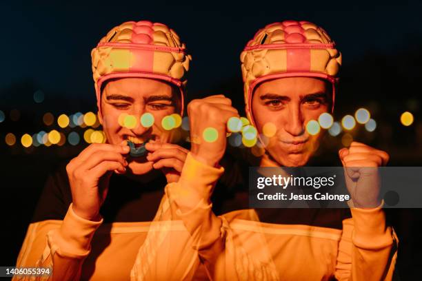 woman, rugby player, with rugby head gear. with her mouthpiece in mouth. rugby, female sport, contact sports concept. style of photography with red lighting. double exposure - rugby esporte stock pictures, royalty-free photos & images