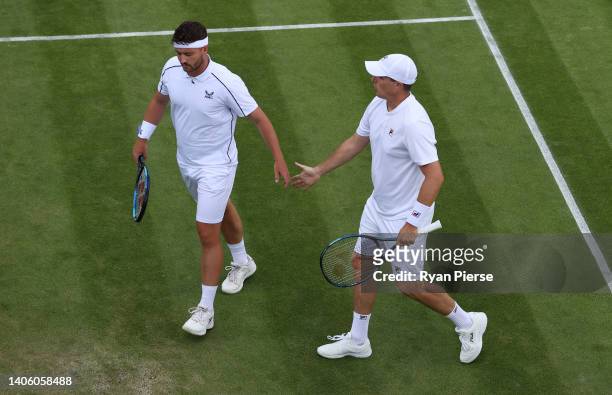 Jonny O'Mara and partner Ken Skupski of Great Britain interact during their Men's Doubles First Round match against Julio Peralta and Alejandro...