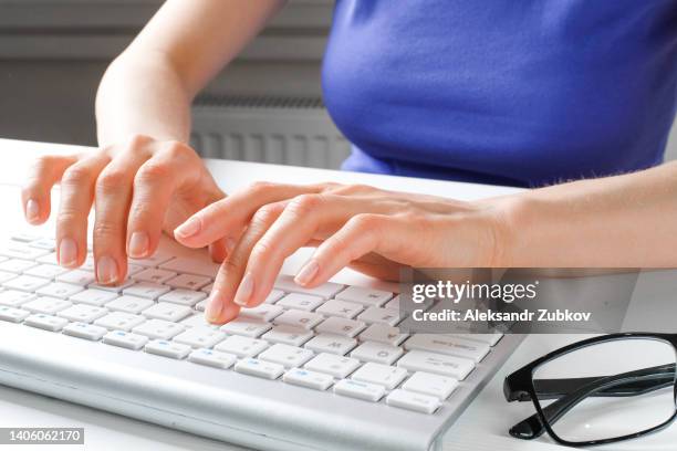 female hands type text on the keyboard of a computer or laptop. a woman, an office worker at her desk. the concept of business, freelancing, work at home. it support, network security, online social support. distance learning online. - registro fotografías e imágenes de stock