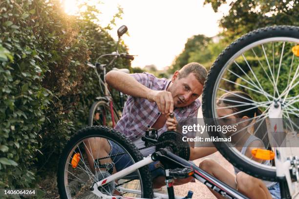 padre e figlia riparano biciclette in città. ciclismo in famiglia - biker girl foto e immagini stock