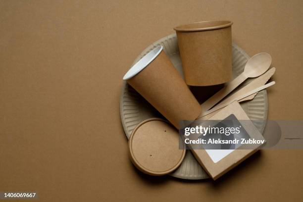 biodegradable disposable tableware made of recyclable plastic and paper on a beige craft background or table. the concept of protection, care and environmental protection. life without plastic. - a plate made of paper stock-fotos und bilder