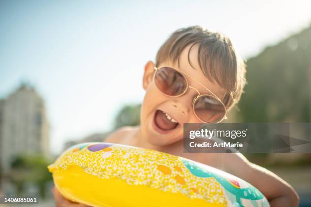 cute child with inflatable ring near the pool - kids pool games stock pictures, royalty-free photos & images