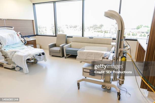 empty hospital room prepared for delivery of a newborn - hospital cot stock pictures, royalty-free photos & images