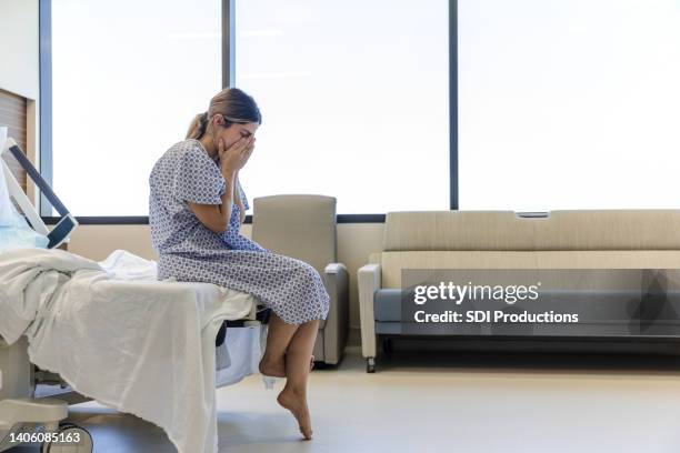 young adult woman holds her face while crying - maternity ward stock pictures, royalty-free photos & images