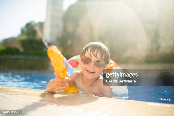 happy little boy having fun in pool - kids pool games stock pictures, royalty-free photos & images