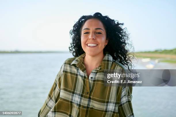 portrait of smiling woman with river in background - plaid shirt stock pictures, royalty-free photos & images