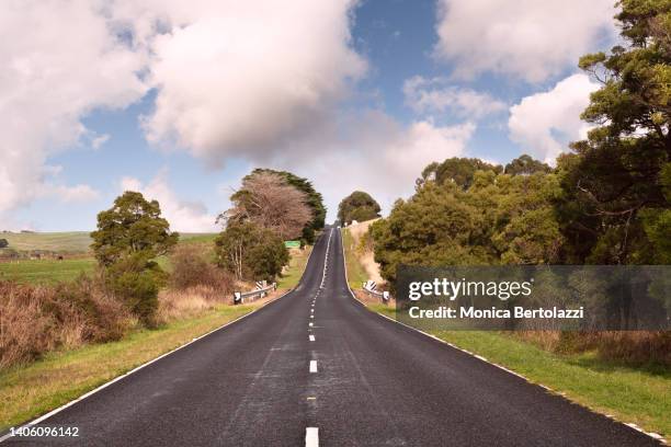 sealed country road  under beautiful cloudy sky - country road australia stockfoto's en -beelden