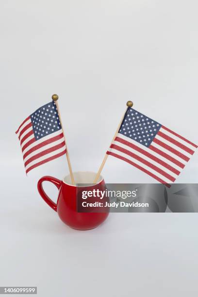 red mug with two american flags on sticks and room for text - amerikanische südstaaten flagge stock-fotos und bilder