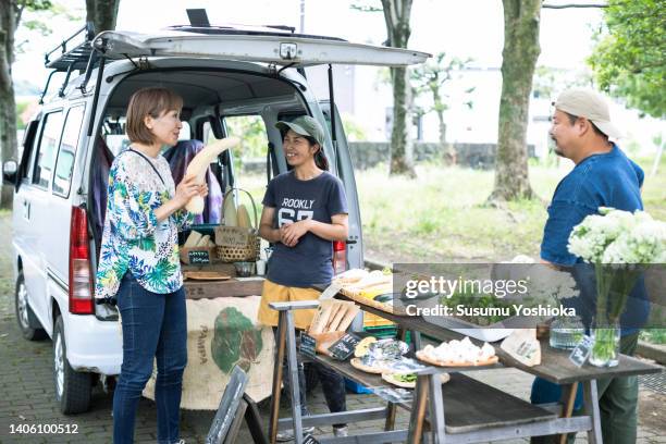 people enjoying shopping at an organic farmers' market. - マルシェ　日本 ストックフォトと画像