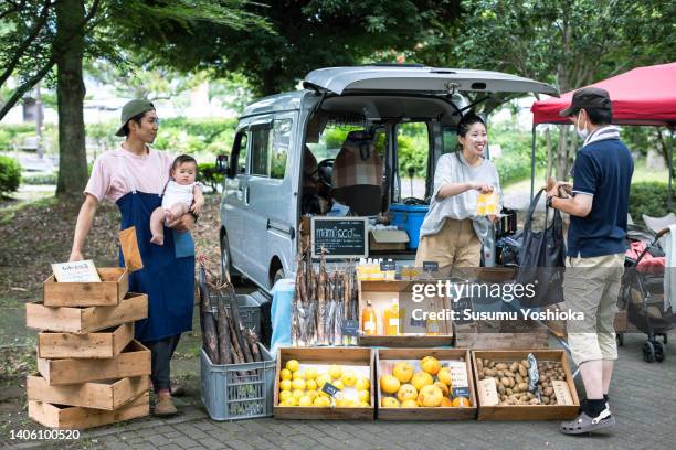 people enjoying shopping at an organic farmers' market. - market stall stock pictures, royalty-free photos & images