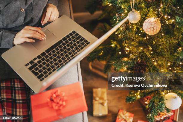 close up of woman hands with, gifts, coffee cup and laptop. online shopping at christmas holidays. freelance girl woking from home office. female typing at notebook computer. christmas moments. - christmas shopping 個照片及圖片檔