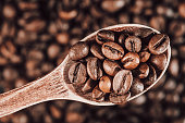 coffee background. wooden spoon with coffee beans. copy space with coffee beans. coffee beans on the dining table. closeup of coffee beans. coffee beans on a plate. coffee with spices