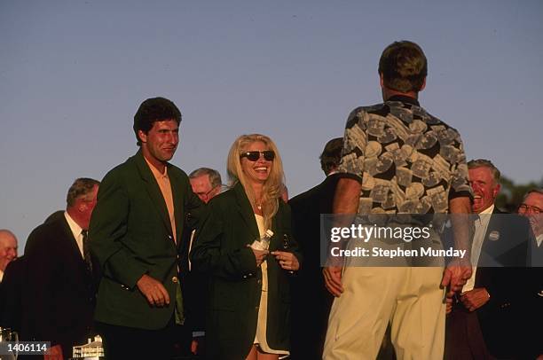 Jose-Maria Olazabal of Spain and Ben Crenshaw of the USA watch as Ben''s wife Julie tries on his green jacket after his victory in the US Masters at...