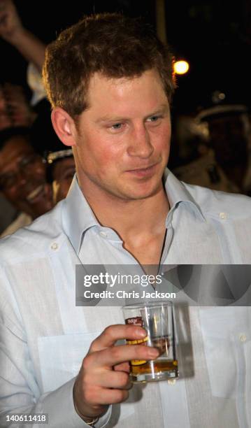 Prince Harry enjoys a drink as he attends a Jubilee Block Party on March 2, 2012 in Belmopan, Belize. The Prince is visiting Belize as part of a...