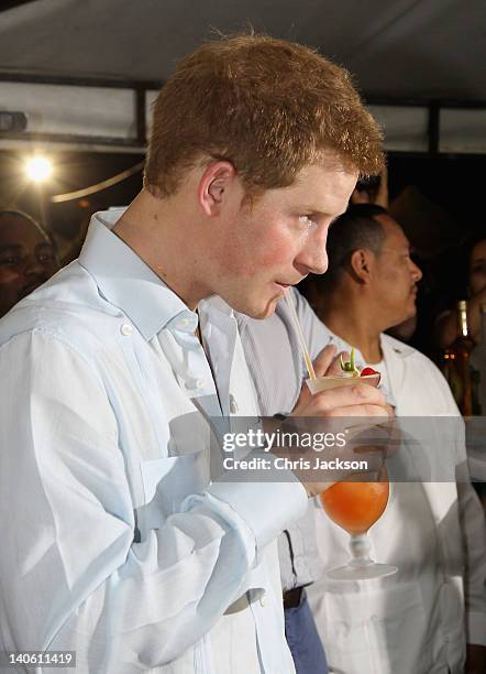 Prince Harry enjoys a drink as he attends a Jubilee Block Party on March 2, 2012 in Belmopan, Belize. The Prince is visiting Belize as part of a...