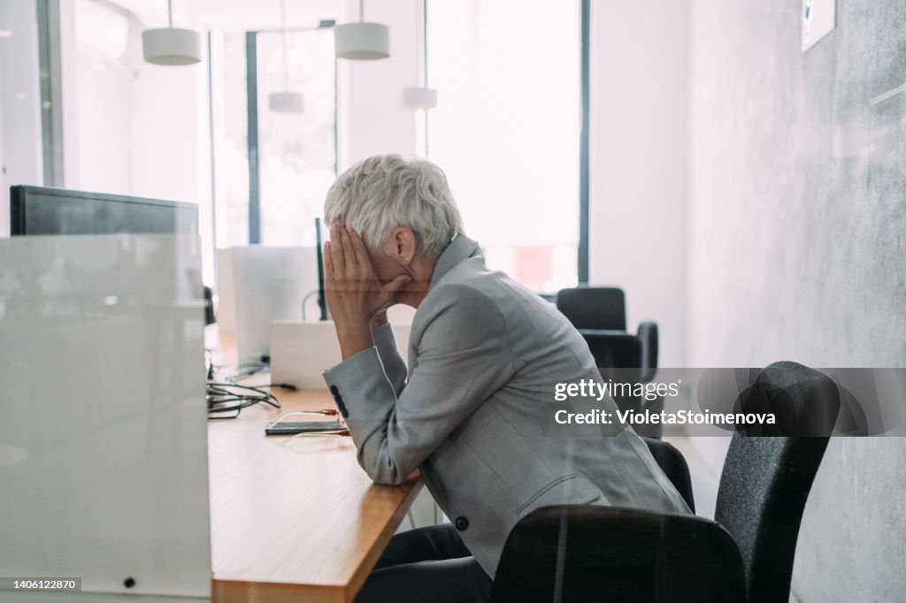 Overworked mature businesswoman in the office.