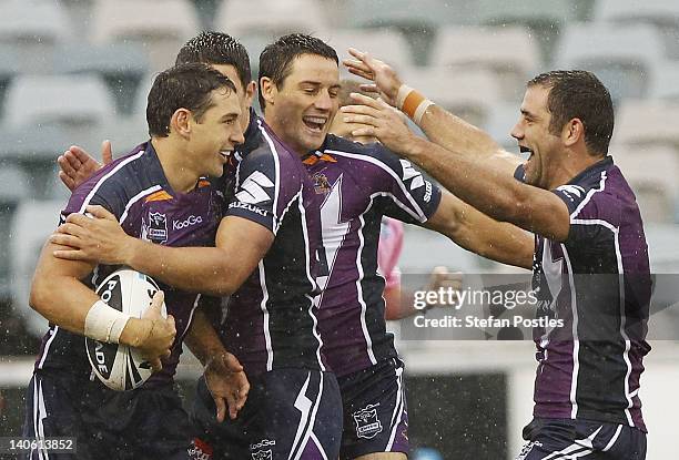 Melbourne Storm players celebrate after Billy Slater scored a try during the round one NRL match between the Canberra Raiders and the Melbourne Storm...
