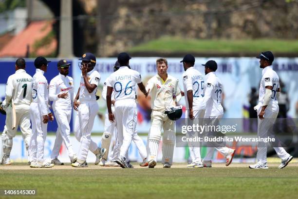 David Warner of Australia is congratulated by Lasith Embuldeniya of Sri Lanka during day three of the First Test in the series between Sri Lanka and...