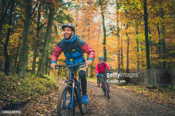 smiling young black man enjoying sport with friends in nature - bike riding bildbanksfoton och bilder