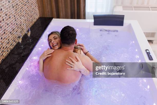 jovem casal compartilhando amor e ternura em banheira de hidromassagem - couple bathtub - fotografias e filmes do acervo