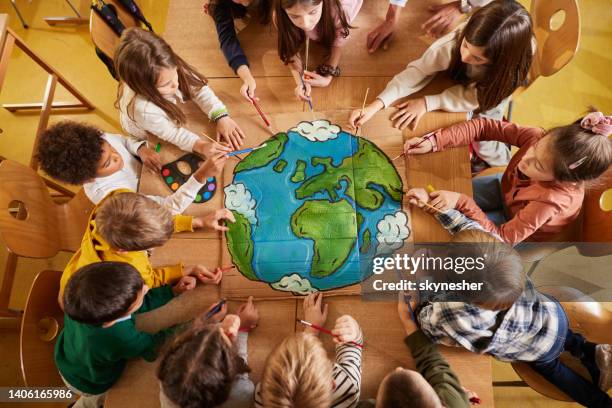 above view of students drawing a planet on art class at elementary school. - kids placard stock pictures, royalty-free photos & images