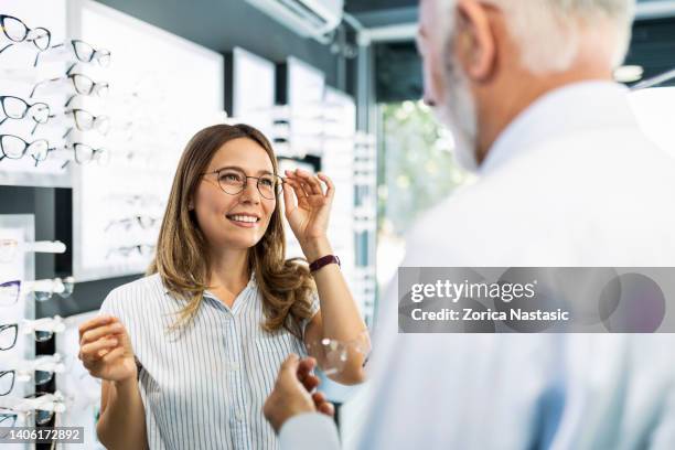 showing eyewear to a customer - reading glasses 個照片及圖片檔