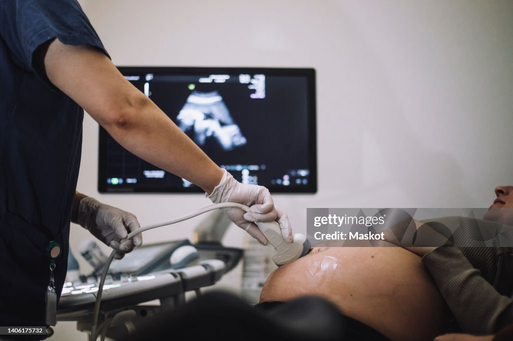 Female gynecologist doing ultrasound of pregnant woman in hospital