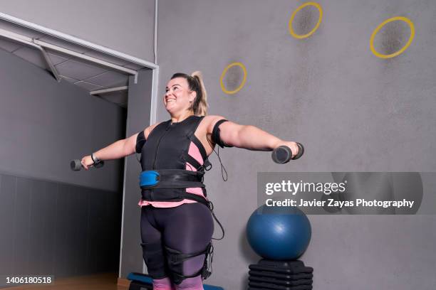 woman doing exercises in electrical muscular stimulation suit - eletródio - fotografias e filmes do acervo