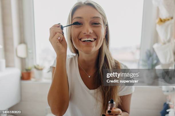 doing make-up is fun and relaxing - woman in bathroom stockfoto's en -beelden